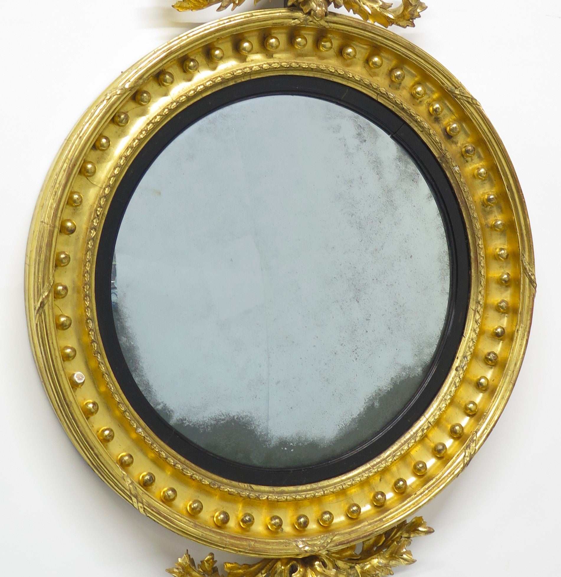 A Superb Early Regency Ebonised and Giltwood Convex Mirror
