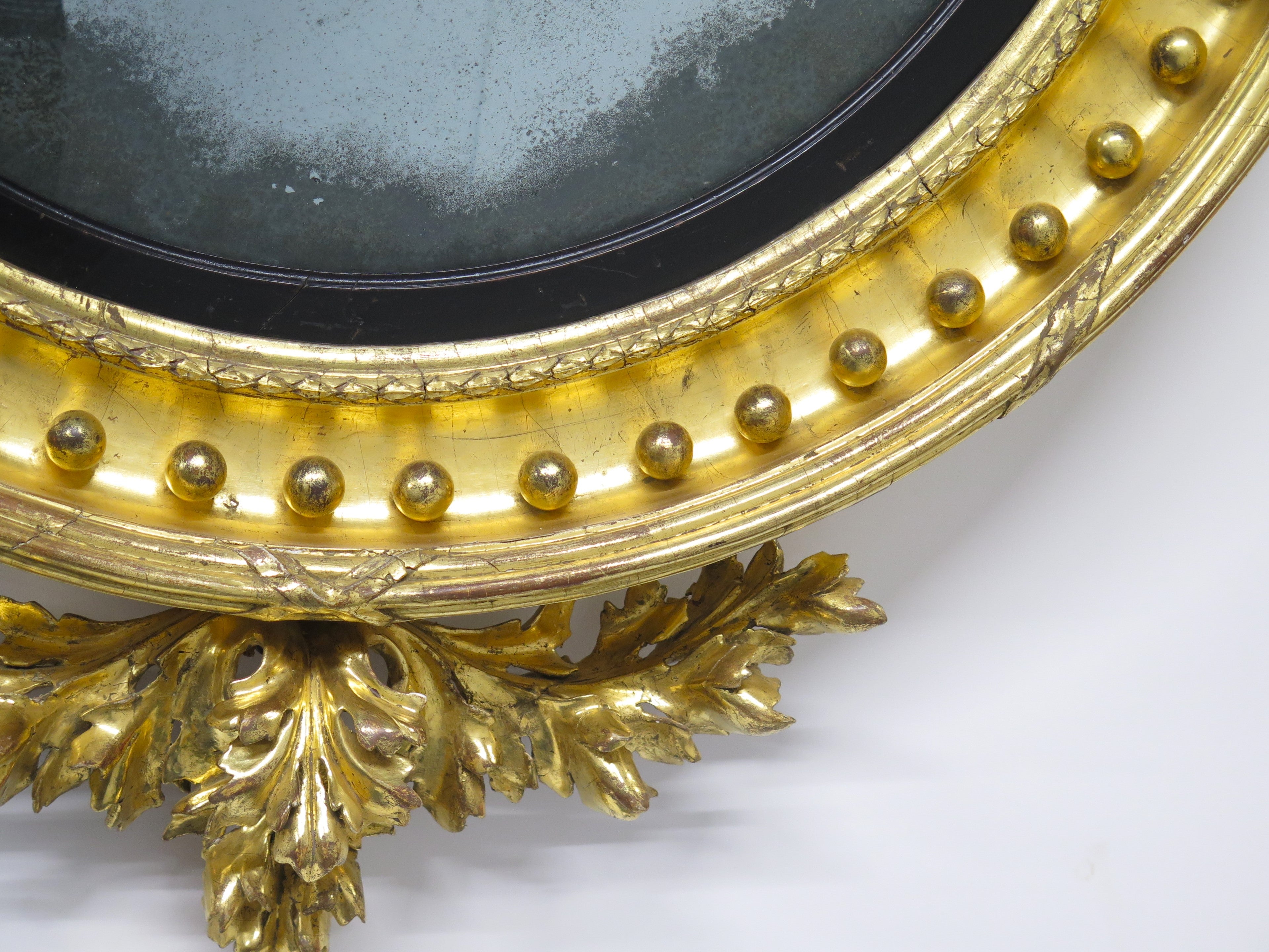 A Superb Early Regency Ebonised and Giltwood Convex Mirror