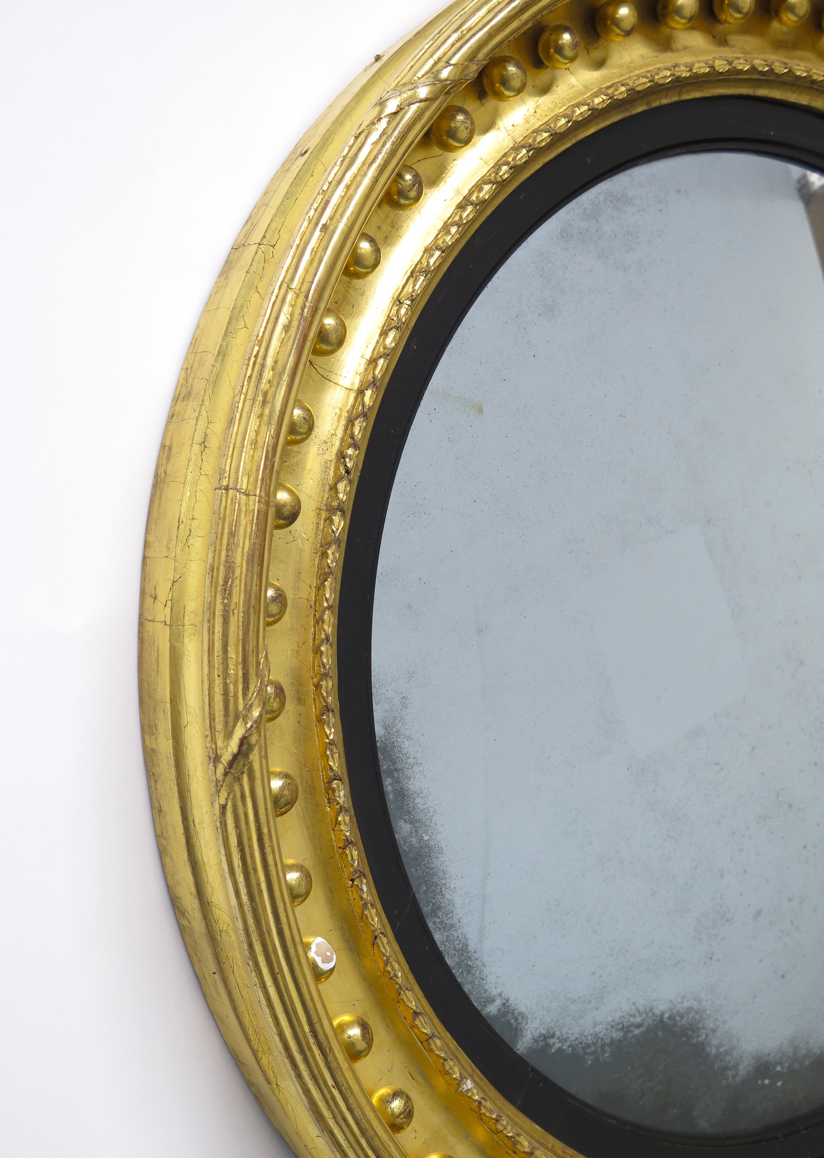 A Superb Early Regency Ebonised and Giltwood Convex Mirror
